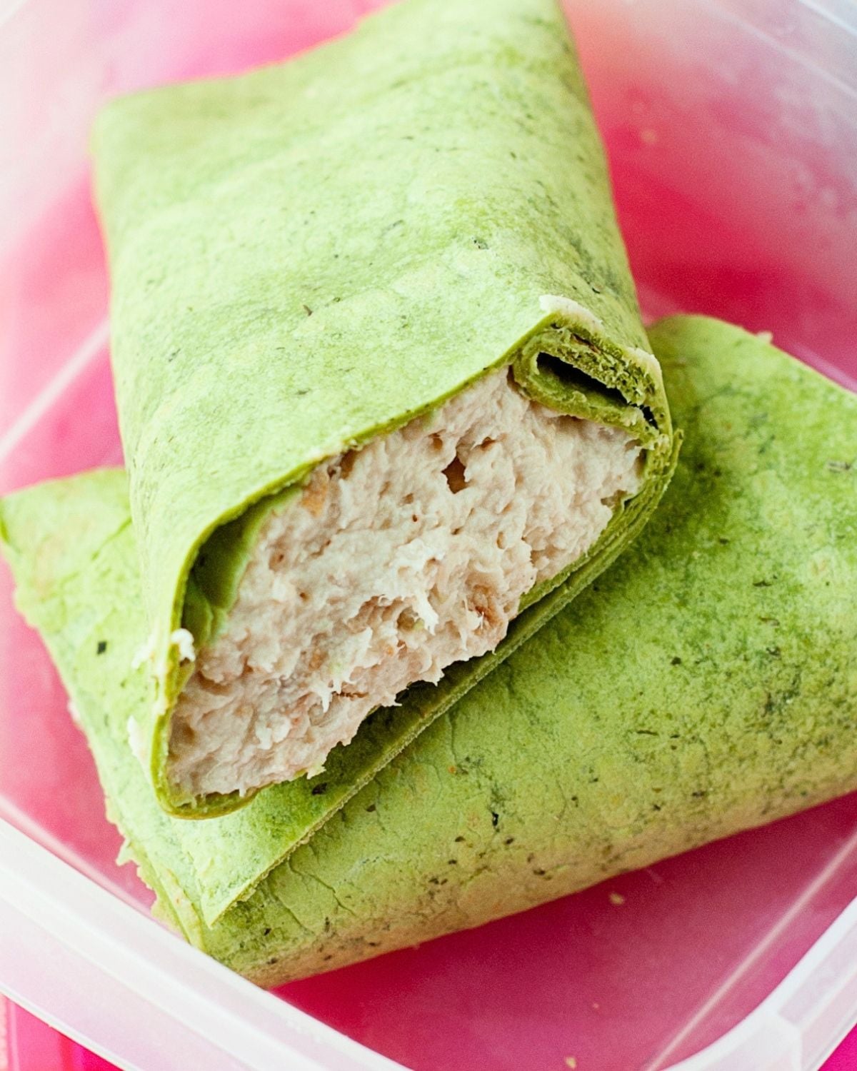 A rotisserie chicken wrap in a lunch container