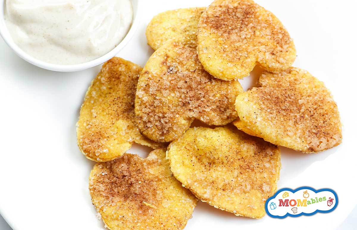 small plate of cinnamon sugar baked chips in the shape of hearts with a small dish of white dip