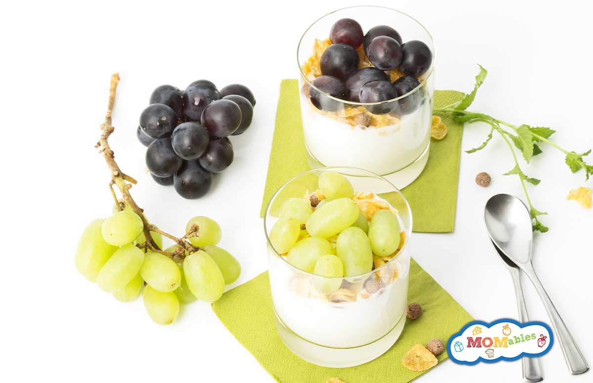 two glasses of grape parfait on paper napkins with grapes on the side