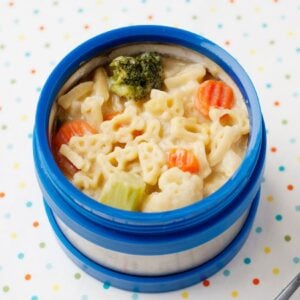 blue thermos with mac and cheese soup with vegetables