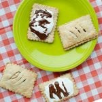 green plate topped with two homemade poptarts, two more poptarts on the counter next to the plate