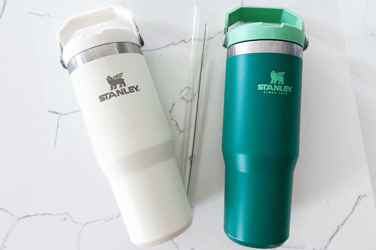 two stanley bottles and straws and straw cleaner on counter 