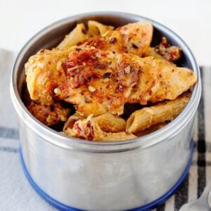 thermos container filled with pasta and sun-dried tomato sauce