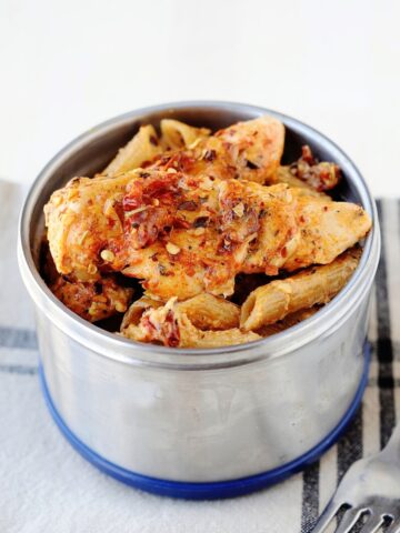 thermos container filled with pasta and sun-dried tomato sauce