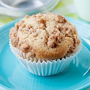 one pear muffin with crumble topping on a blue plate 