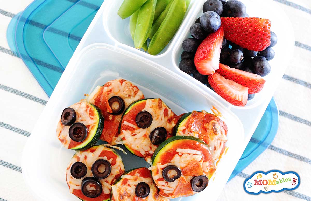 zucchini pizza bites in a school lunch container with fruit and veggie sides