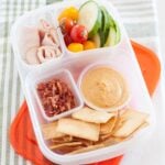 healthy cali lunch box: pita wedges, bacon, ham, cucumber slices, tomatoes and dip
