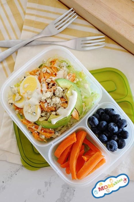 Image: Buffalo Chicken Salad with dressing in a divided lunch container. Carrot sticks and blueberries fill the other two container sides.