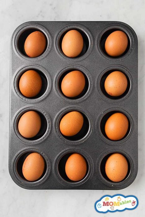 a dozen brown eggs in a muffin tin