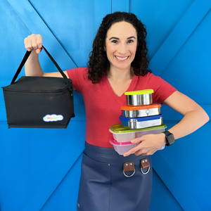 Laura Fuentes holding a stack of lunchboxes and a school lunch bag
