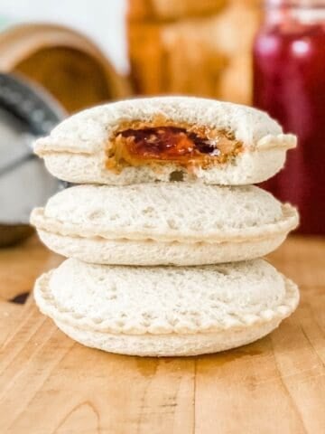 a stack of 3 uncrustables filled with peanut butter and jelly