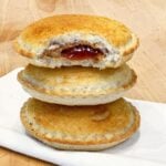 a stack of three uncrustables stacked on top of each other. They are golden and crisp because they've been toasted in the air fryer