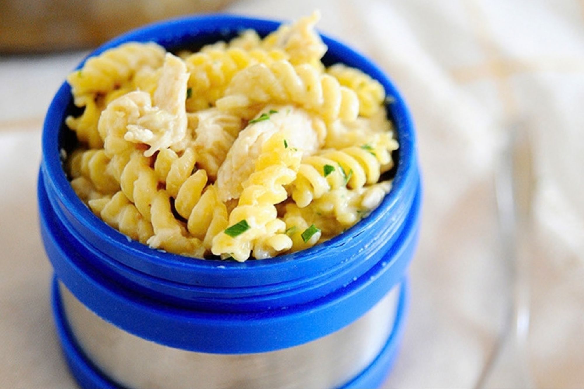 salsa verde chicken pasta in a blue thermos lunch container
