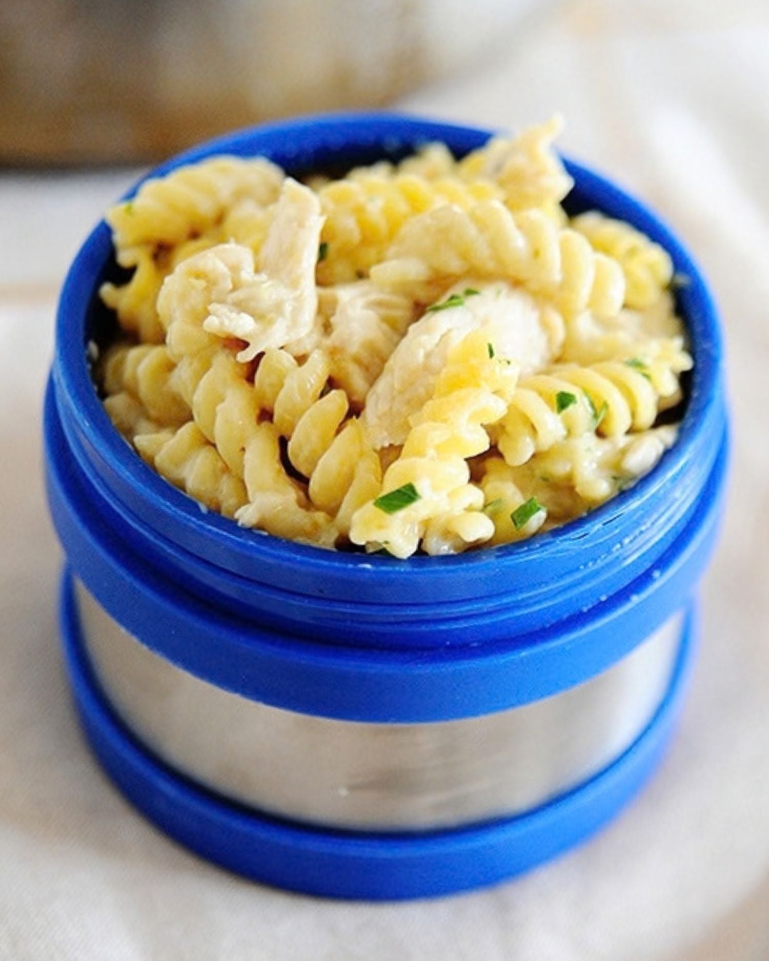salsa verde chicken pasta in a blue thermos lunch container