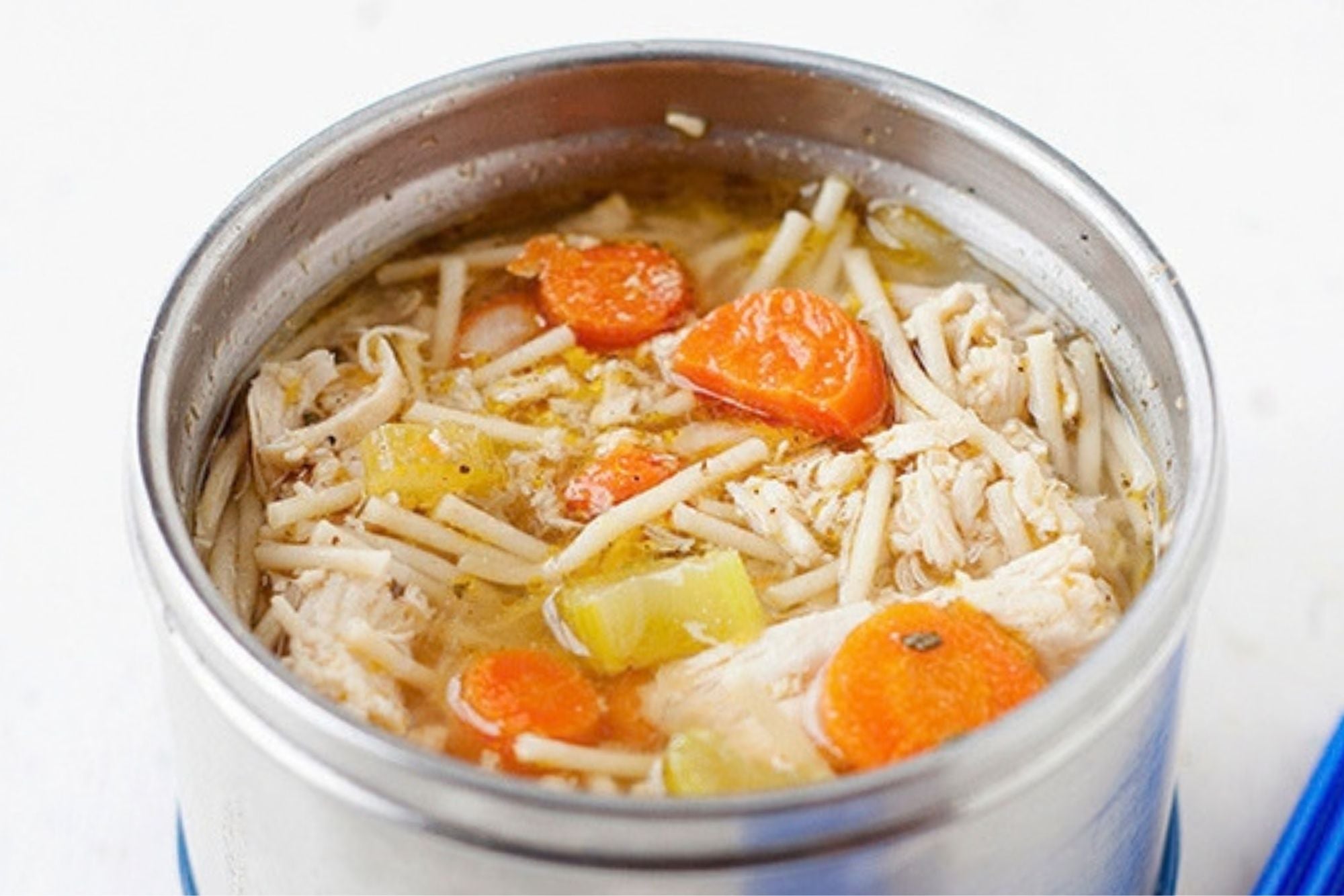 A thermos filled with homemade chicken noodle soup