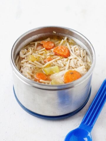 A thermos filled with homemade chicken noodle soup