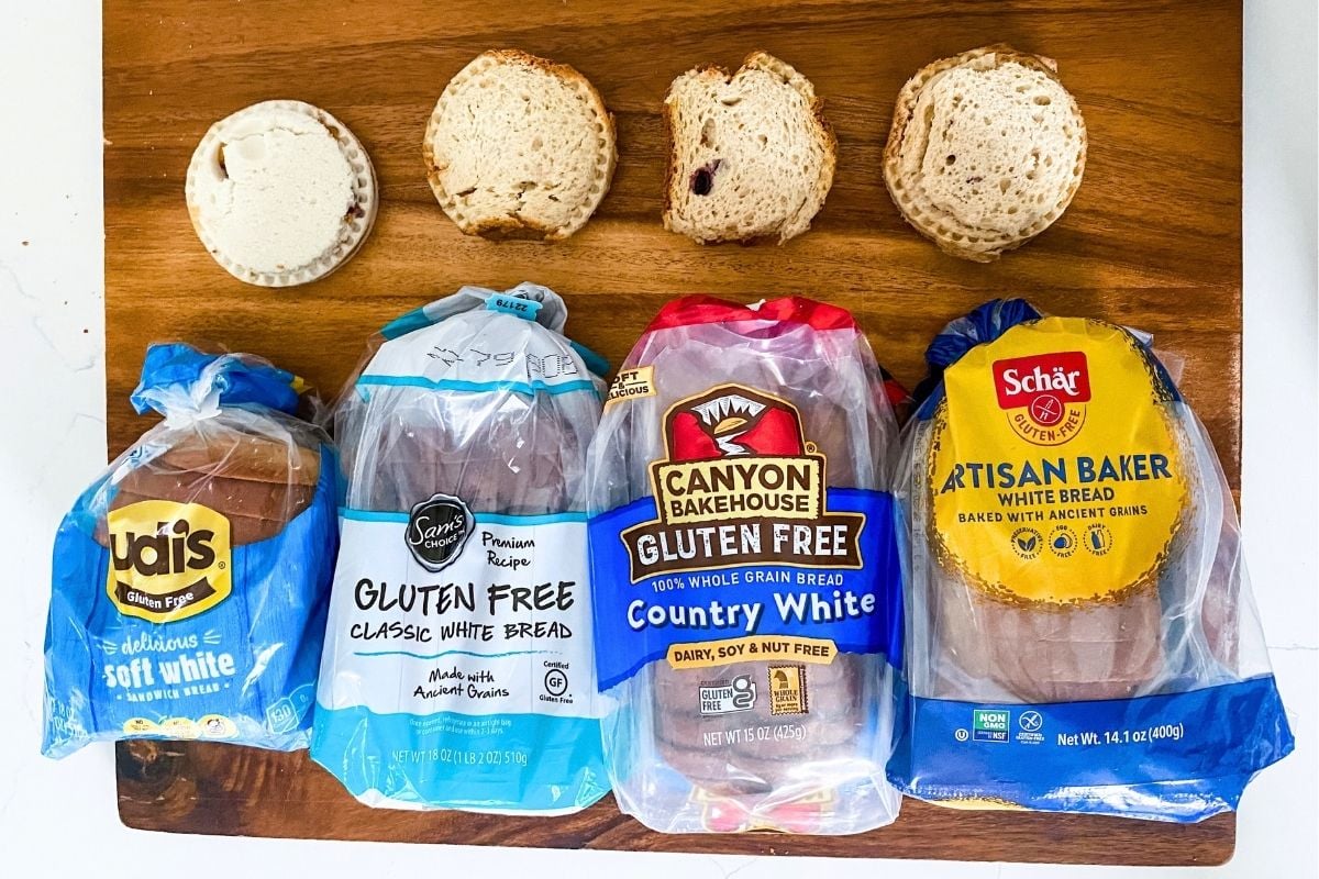four gluten-free uncrustables on a cutting board with four different types of gluten free bread loaves