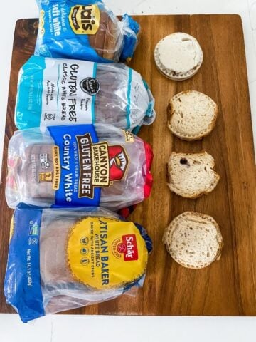 four gluten-free uncrustables on a cutting board with four different types of gluten free bread loaves