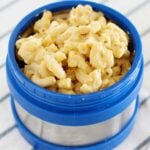 blue lunch thermos filled with macaroni and cheese