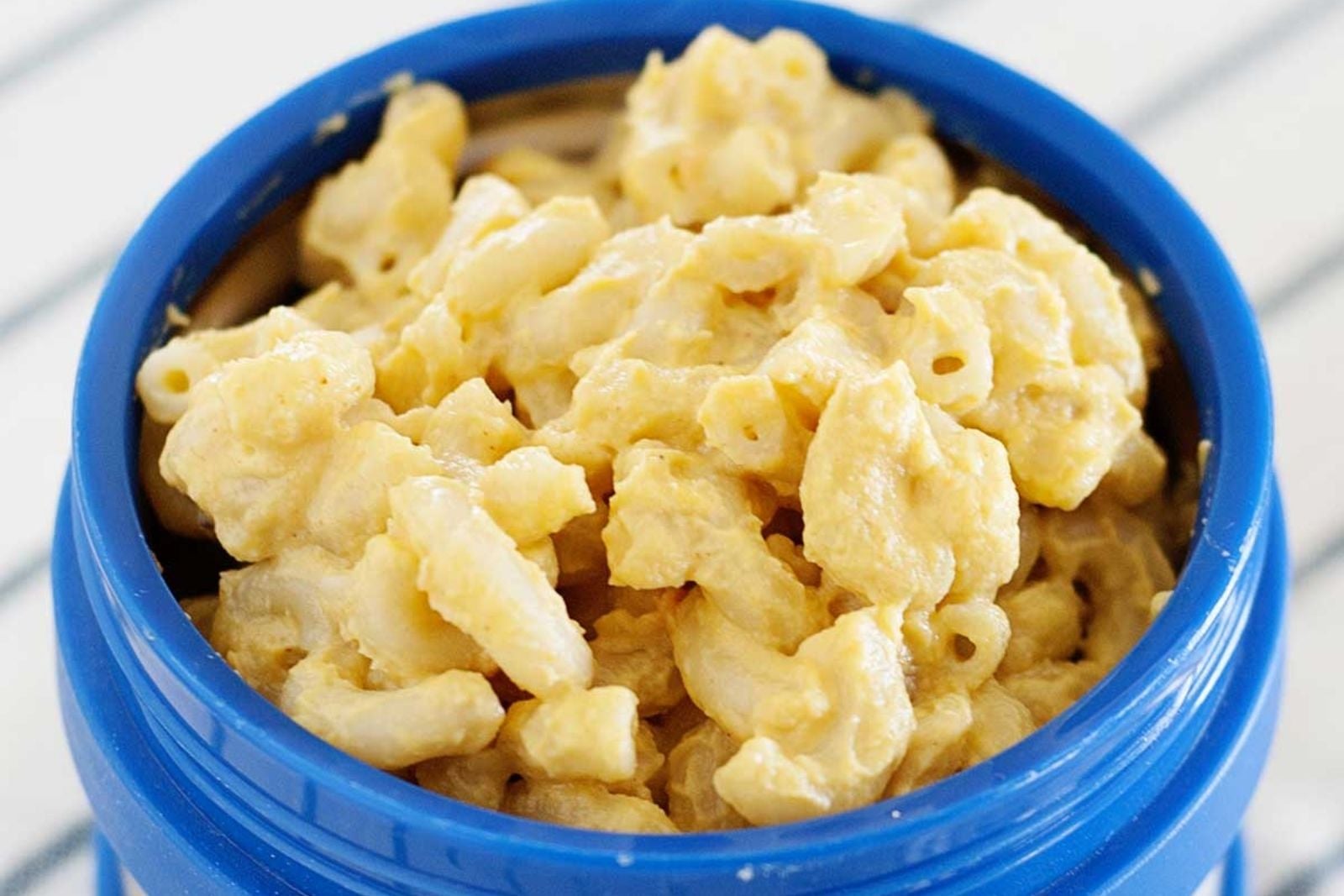 blue lunch thermos filled with macaroni and cheese
