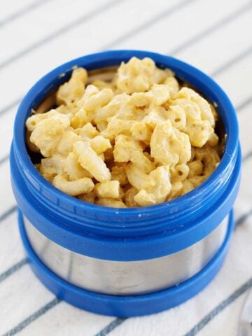blue lunch thermos filled with macaroni and cheese