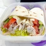 two halves of a chicken avocado wrap in a lunchbox