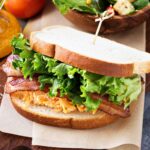 pimento cheese btl sandwich on a wooden board