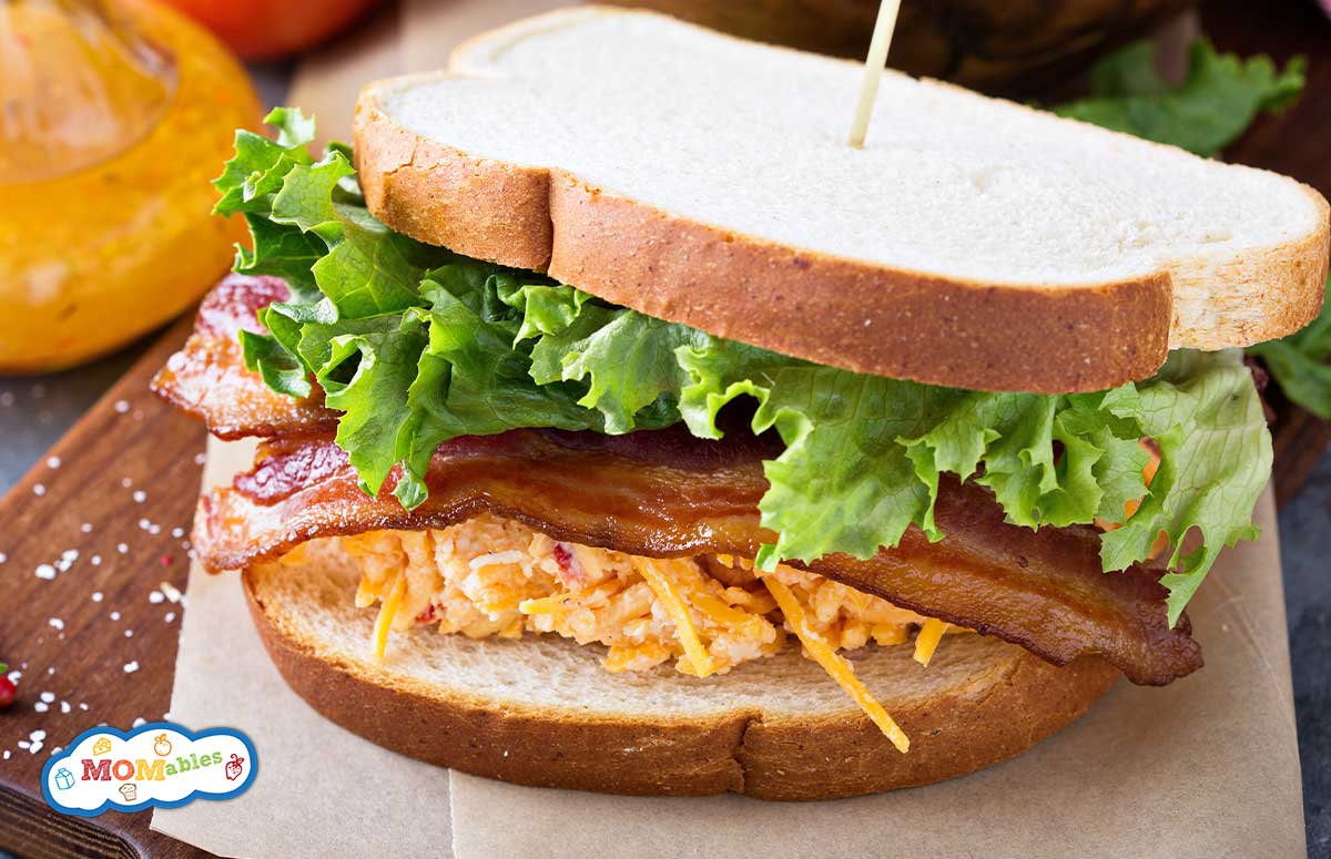 pimento cheese bacon tomate lettuce sandwich on a wooden board