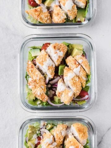 three glass lunch containers with chicken strip salad
