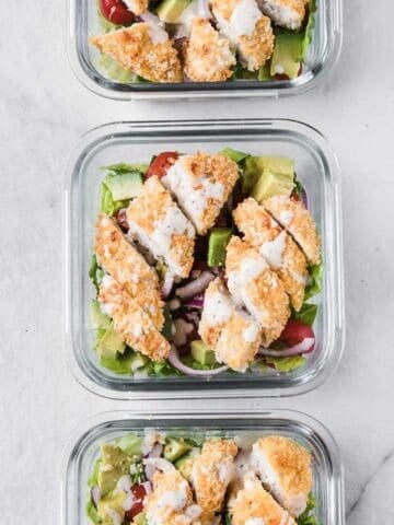 three glass lunch containers with chicken strip salad