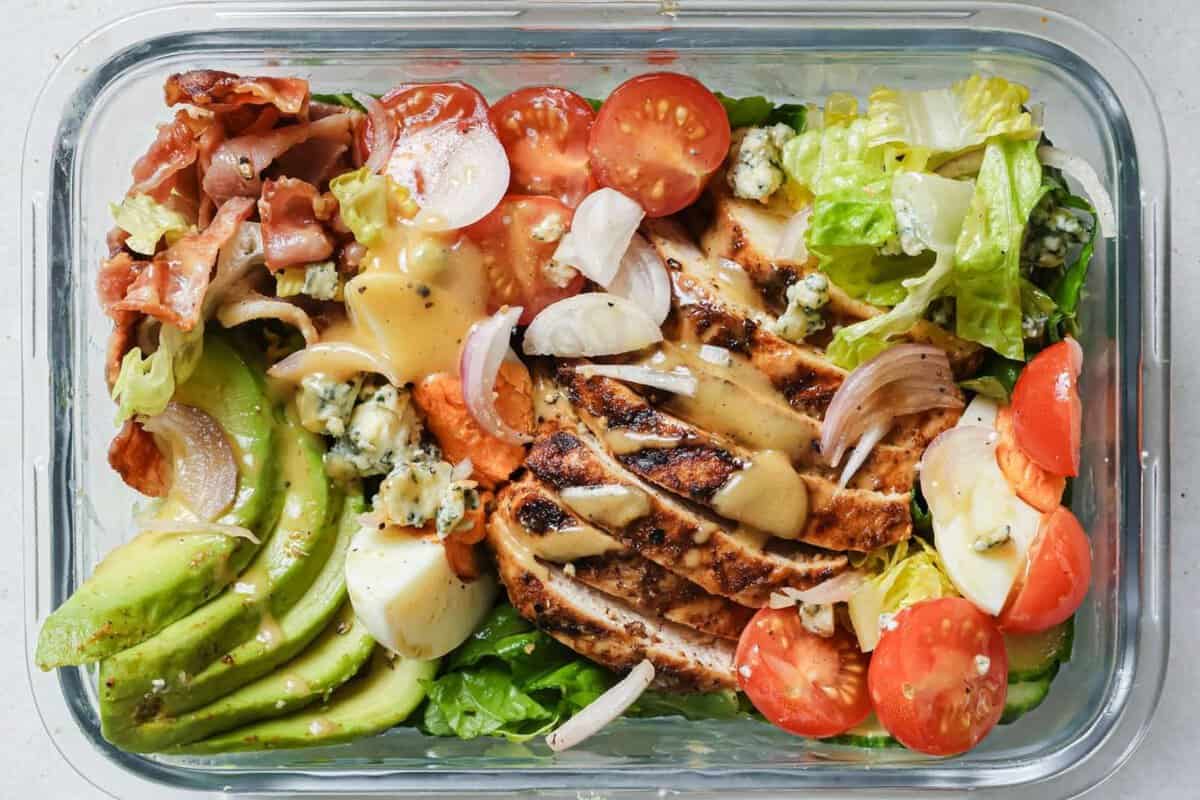 overhead view of a glass lunchbox with cobb salad
