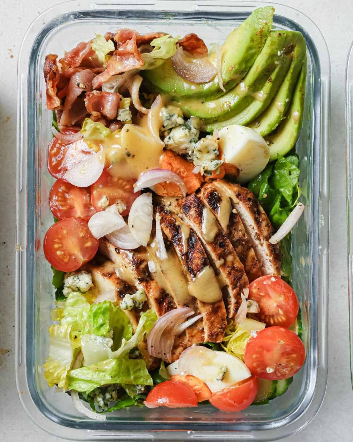 overhead view of a glass lunchbox with cobb salad