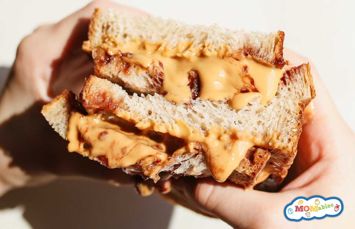a person holding a peanut butter sandwich