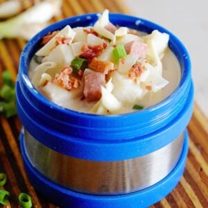 blue thermos filled with potato soup, and topped with bacon