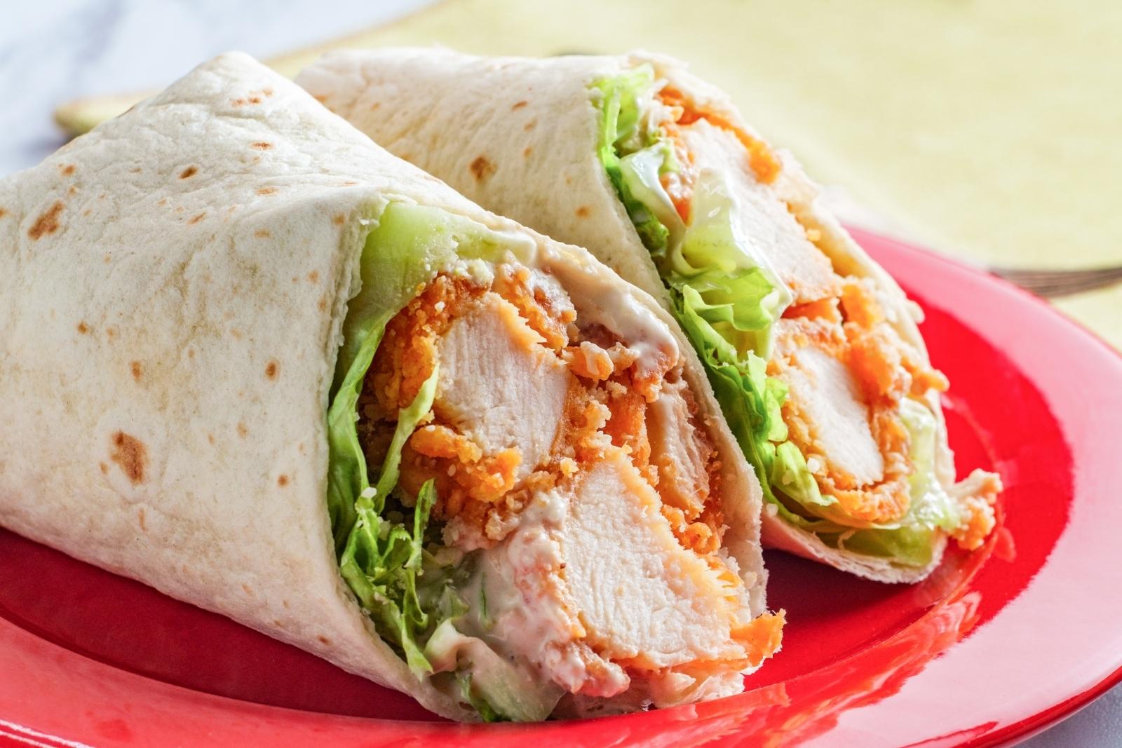 crispy chicken wrap sliced in half on a plate
