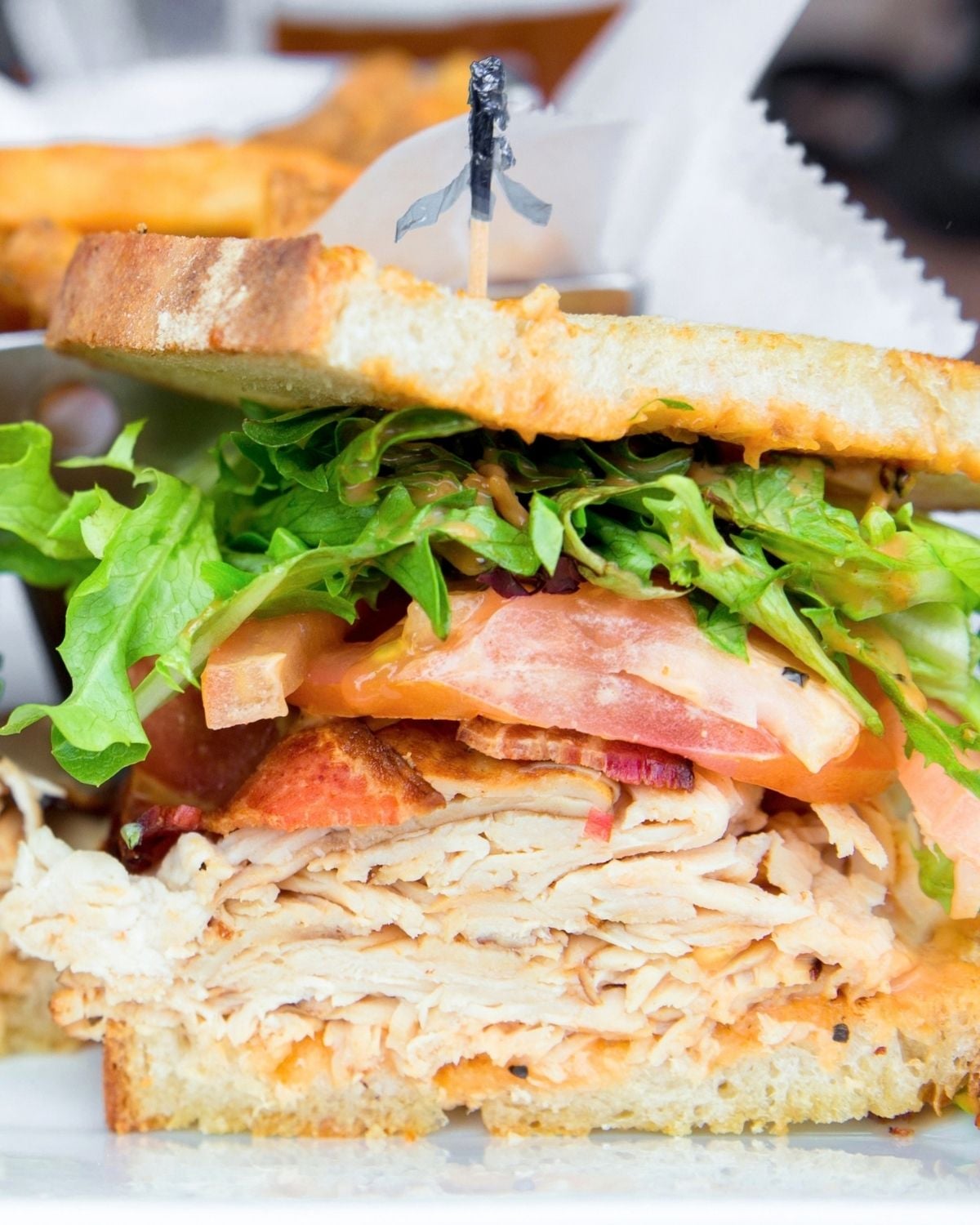 sandwich with chicken, bacon, and veggies