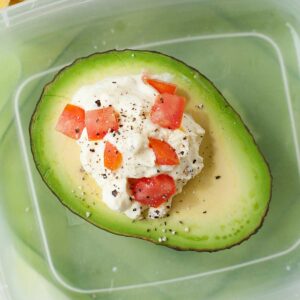 closeup of an avocado half stuffed with egg salad