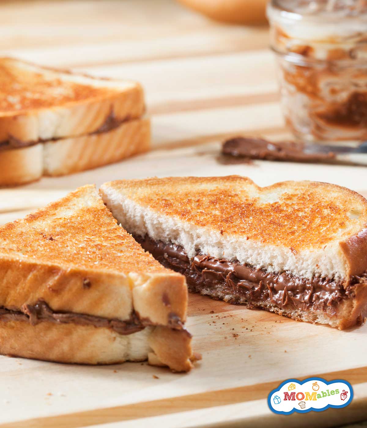 a grilled nutella sandwich on a cutting board after being cut in half