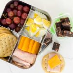 bento container with several protein ingredients and a small container of lara bars cut into cubes