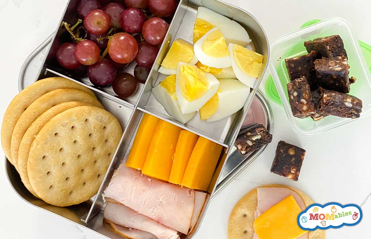 bento box with lara bars, turkey, cheese, grapes and crackers