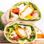 two halves of a chicken nugget wrap filled with veggies and ranch dressing