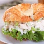 chicken salad croissant with a large lettuce leaf on the sandwich
