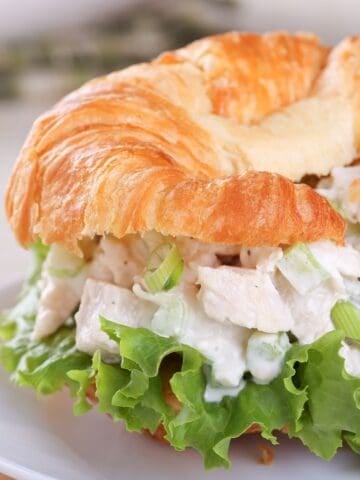 chicken salad croissant with a large lettuce leaf on the sandwich