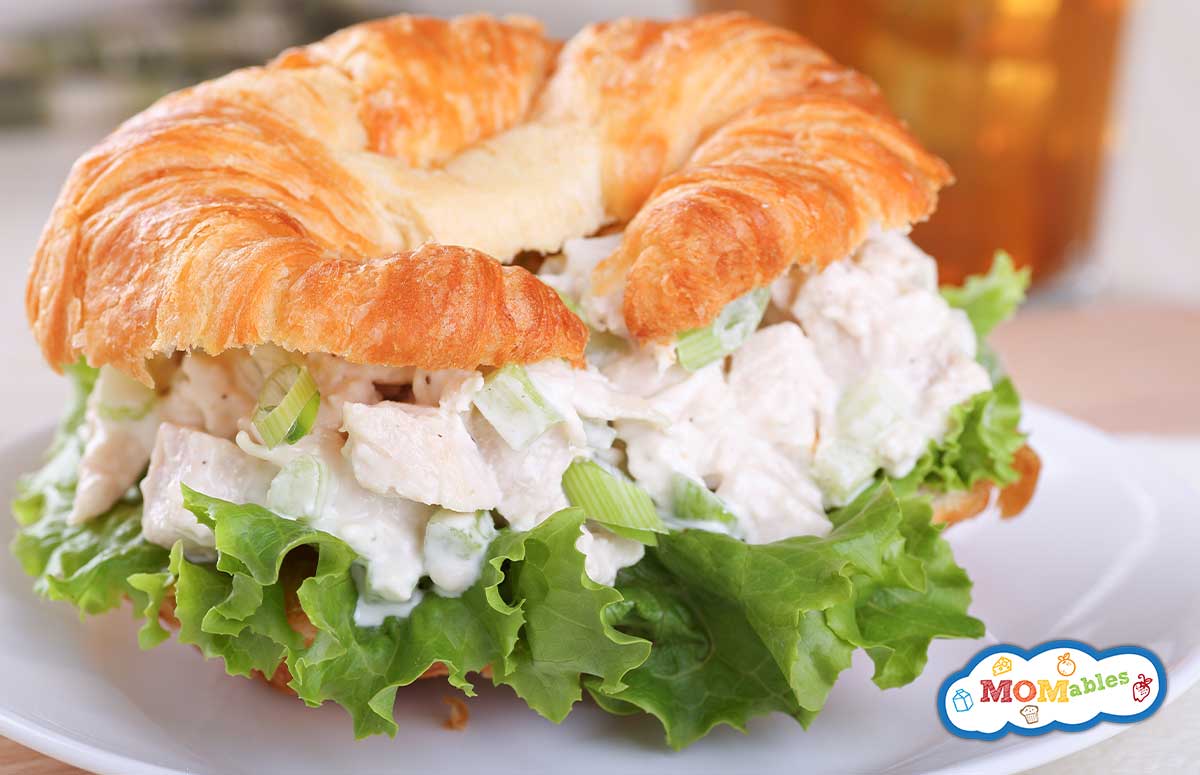 chicken salad croissant with a large lettuce leaf on the sandwich