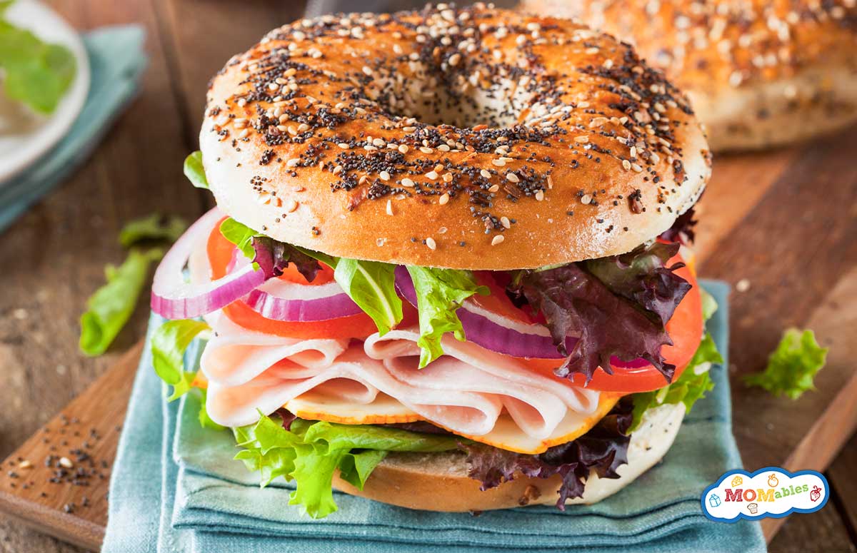 veggies and turkey on an everything bagel sandwich