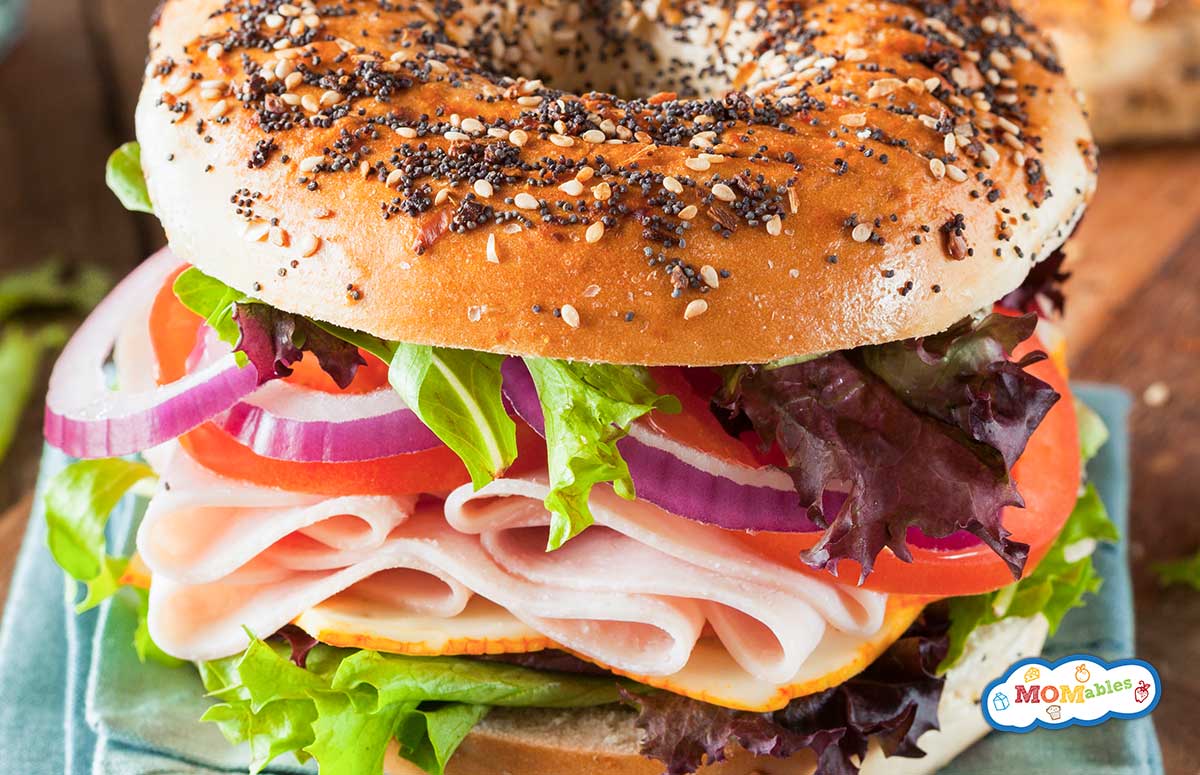closeup on a turkey and veggie everything bagel sandwich