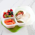 canned chicken wrap in a lunch container with veggies and fresh fruit