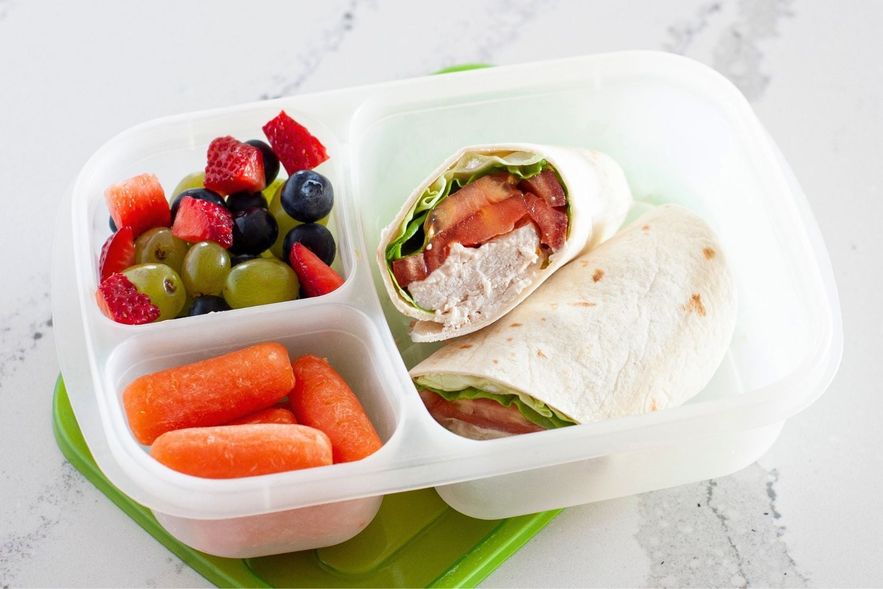 canned chicken wrap in a lunch container with veggies and fresh fruit