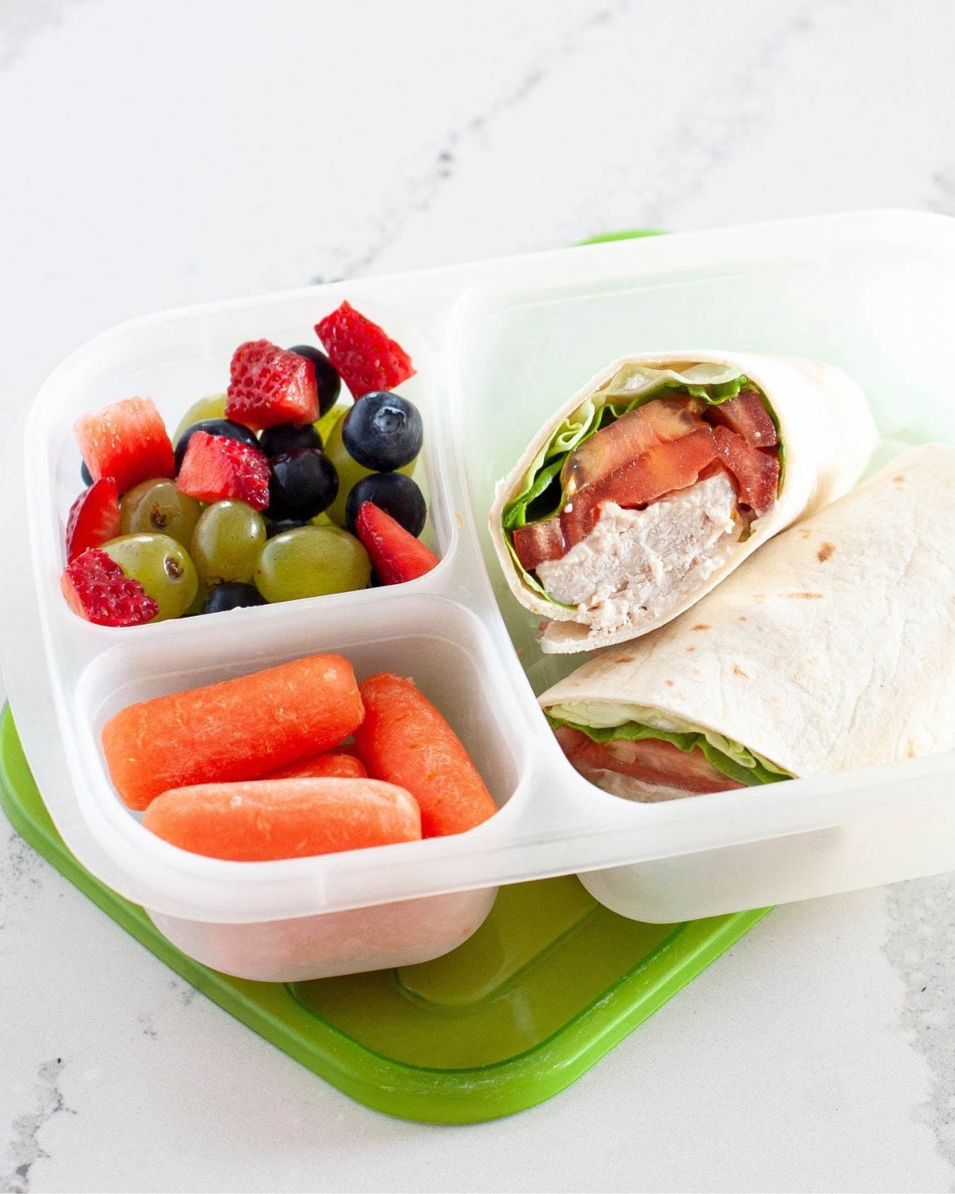 canned chicken wrap in a lunch container with veggies and fresh fruit