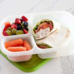 canned chicken wrap in a lunch container with veggies and fruit
